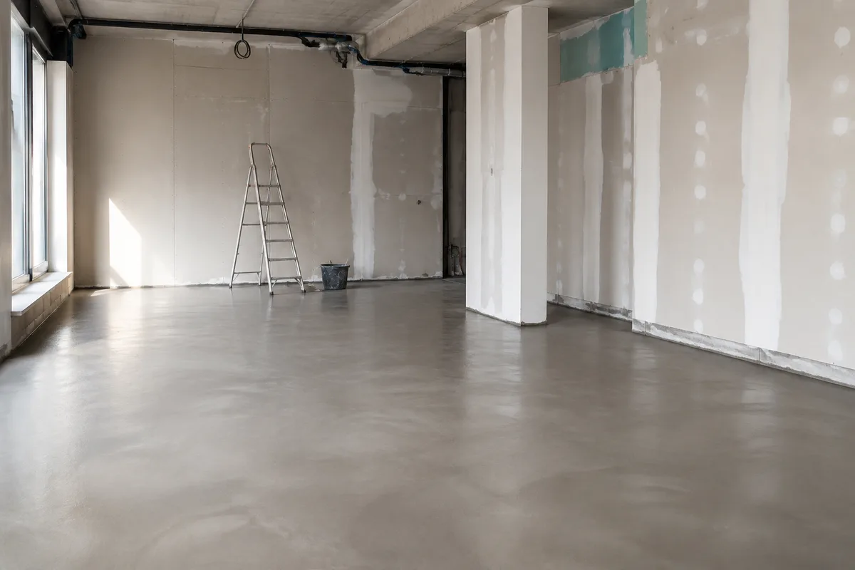 Local commercial vide en cours de rénovation, murs bruts et sol préparé