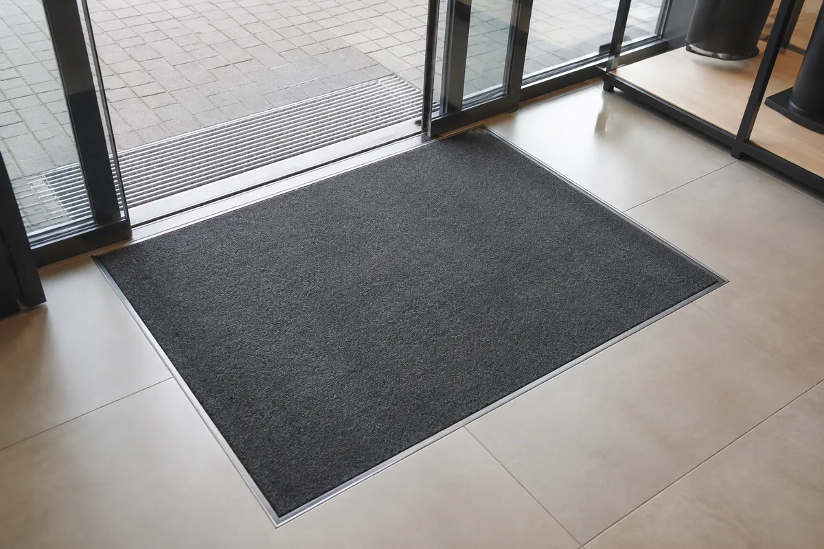 Sol en grès cérame dans une boutique, zone d&rsquo;entrée avec tapis encastré