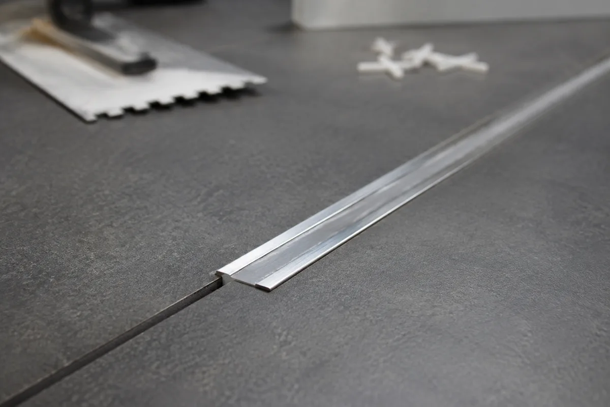 Profile de fractionnement en inox pose entre deux zones de carrelage gres cerame